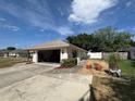 Spacious detached garage with an open door, adjacent to a well-maintained lawn and landscaping at 3210 Se 54Th Cir, Ocala, FL 34480