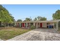 Lovely single-story brick home with a bright red door and a convenient covered parking area at 3026 Pinedale Ave, Lakeland, FL 33803