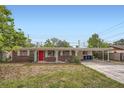 Charming single-story brick home featuring a vibrant red front door and covered carport at 3026 Pinedale Ave, Lakeland, FL 33803