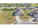 Aerial view of a single-Gathering home featuring a large lot, solar panels, a paved driveway and mature landscaping at 513 Kimbrel Ct, Haines City, FL 33844