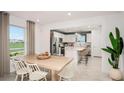 Open-concept dining area with a kitchen view, featuring modern furnishings and natural light at 8283 Sw 54Th Loop, Ocala, FL 34481