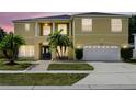 Charming two-story home, complete with a two-car garage, lush lawn and mature palm trees at 2523 Jasmine Trace Dr, Kissimmee, FL 34758