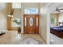 Grand foyer with soaring ceilings, beautiful tile flooring, and a decorative wood front door at 2523 Jasmine Trace Dr, Kissimmee, FL 34758