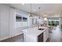Bright kitchen with a large island, white cabinets, and stainless steel dishwasher under the counter at 5832 Sw 87Th Ave, Ocala, FL 34481
