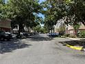 Street view lined with lush trees and parked cars along the side of multi-story apartments at 13103 Mulberry Park Dr # 833, Orlando, FL 32821