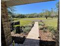 View of the beautiful, brick-paved front porch with brick columns and landscaped garden leading to the home at 1275 Man O War Dr, Deland, FL 32724