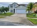 Two-story home featuring a two-car garage, front lawn with palm trees, and neutral-colored exterior at 1416 Aguacate Ct, Orlando, FL 32837