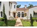 Elegant home featuring a tile roof and arched doorways, surrounded by manicured landscaping at 1239 Roycroft Ave, Kissimmee, FL 34747