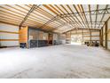 Spacious barn featuring high ceilings, multiple horse stalls, and ample storage for equipment and supplies at 24025 Ranch Rd, Astatula, FL 34705