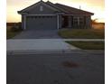 Single-story home featuring a tile roof, manicured lawn, and brick-paved driveway at 4616 Grandview Glen Dr, Auburndale, FL 33823