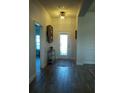 Bright foyer with wood-look tile flooring, white trim, decorative console table, and front door with glass panels at 4616 Grandview Glen Dr, Auburndale, FL 33823