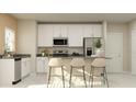 Modern kitchen with white cabinets, stainless steel appliances, and barstool seating at 7244 Summer Ivy Aly, Orlando, FL 32829