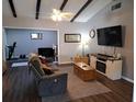 Comfortable living room with wood floors, ceiling fan, exposed beams, and abundant natural light at 242 Rosa Blanca, Winter Haven, FL 33884