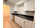 Modern kitchen featuring white cabinets, granite countertops, and stainless steel appliances at 1505 Piedmont Dr, Deltona, FL 32725