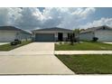 Inviting single-story home featuring a two-car garage and a neatly landscaped front yard at 1351 Pompay Dr, Davenport, FL 33896
