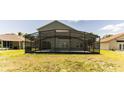 The backyard has a screened-in pool area and green lawn at 2433 Huron Cir, Kissimmee, FL 34746