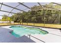 A beautiful screened-in pool is surrounded by green space and trees at 2433 Huron Cir, Kissimmee, FL 34746