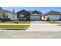 A view of the neighborhood with the charming single-story house, featuring a two-car garage and front lawn at 5944 Bristle Oak St, Mount Dora, FL 32757