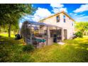 Spacious backyard featuring a screened pool enclosure, lush green lawn, and a view of the home's rear facade at 1142 Mariner Cay Dr, Haines City, FL 33844