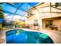 Inviting pool and patio area with a screened-in enclosure, outdoor dining, and a backyard view at 1142 Mariner Cay Dr, Haines City, FL 33844