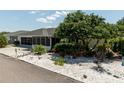 Home exterior featuring well maintained landscaping and a beautiful mature shade tree at 7040 Tamarind Dr, Lake Wales, FL 33898