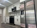 An updated kitchen features white cabinets, stainless steel appliances, and a decorative backsplash at 12020 Villanova Dr # 107, Orlando, FL 32837