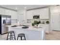 Bright kitchen featuring white cabinets, stainless steel appliances, and a central island with bar seating and modern faucet at 5629 Gingham Dr, Kissimmee, FL 34758
