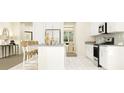 Bright, modern kitchen with white cabinets, stainless appliances, and an eat-in island at 1283 Dora Parc Ln, Mount Dora, FL 32757