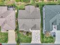 Aerial view of home with a well-manicured lawn, mature landscaping, and a unique patterned driveway at 1709 Latta Ct, The Villages, FL 32162