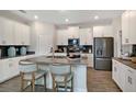 Modern kitchen features stainless steel appliances, gray countertops, an island, and white cabinets at 1899 Clear Sky Dr, Kissimmee, FL 34744