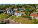 Charming two-story home with terracotta roof and manicured yard nestled amongst mature trees at 2417 Coventry Ave, Lakeland, FL 33803