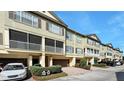 Townhouse complex with garages, screened balconies, manicured landscaping, and brick-paved driveways at 2352 Grand Central Pkwy # 18, Orlando, FL 32839