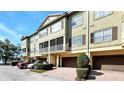A multi-story condo building with brick-paved driveways, trimmed bushes, and cream-colored stucco at 2352 Grand Central Pkwy # 18, Orlando, FL 32839
