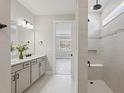 Bright bathroom with double vanity, tiled shower with bench, and modern fixtures at 2797 Top Hill Ct, Minneola, FL 34715