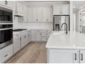 Modern kitchen with white cabinetry, stainless steel appliances, and a spacious center island at 2797 Top Hill Ct, Minneola, FL 34715