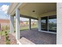 Covered outdoor patio with brick flooring, offering a relaxing space overlooking the landscaped backyard at 2797 Top Hill Ct, Minneola, FL 34715