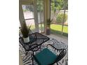 Inviting screened lanai with a metal table, two chairs, and a view of the beautifully landscaped yard at 1087 Jackson St, The Villages, FL 32162