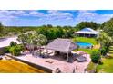 Backyard oasis with lush landscaping, a tiki hut, and an above-ground pool at 1395 S Lake Reedy Blvd, Frostproof, FL 33843