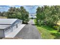 Aerial view of a home with a detached four-car garage with mature trees lining the driveway at 1395 S Lake Reedy Blvd, Frostproof, FL 33843