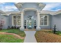 Elegant front entrance with stately columns, a charming water feature, and a beautifully designed blue front door at 2161 Longleaf Cir, Lakeland, FL 33810