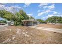 View of home showing long driveway, covered carport and small screened porch at 129 5Th Jpv St, Winter Haven, FL 33880