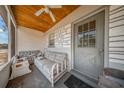 View of Screened porch with ceiling fan, seating and the front door entrance at 129 5Th Jpv St, Winter Haven, FL 33880