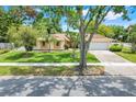 Charming single-story home with manicured lawn, mature trees, and a welcoming two-car garage at 1604 Nottingham Dr, Winter Park, FL 32792