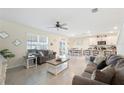 Bright living area with neutral tones, a ceiling fan, and easy access to the kitchen and dining area at 5616 Siltstone St, Lakeland, FL 33811