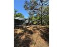 Backyard view of a cozy home featuring a deck and a shaded carport with ample space at 4266 County Road 691, Webster, FL 33597