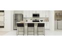 Bright, modern kitchen featuring white cabinets, stainless steel appliances, and a center island with seating at 3019 Totem Rd, Eagle Lake, FL 33839