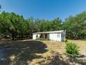 Quaint one-story home featuring a covered porch with mature trees around the home and spacious yard at 6702 Brookridge Trl, Lakeland, FL 33810