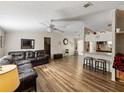Inviting living room with wood floors, fan, and open view to the kitchen with a breakfast bar at 6702 Brookridge Trl, Lakeland, FL 33810