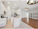 Bright kitchen features white cabinets, stainless appliances, and a breakfast bar overlooking the living area at 1046 Island Pointe Dr, Winter Garden, FL 34787