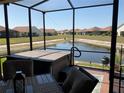 Screened-in patio with a view of the pond, featuring a hot tub and outdoor seating at 1415 Colonial Ct, Winter Haven, FL 33884